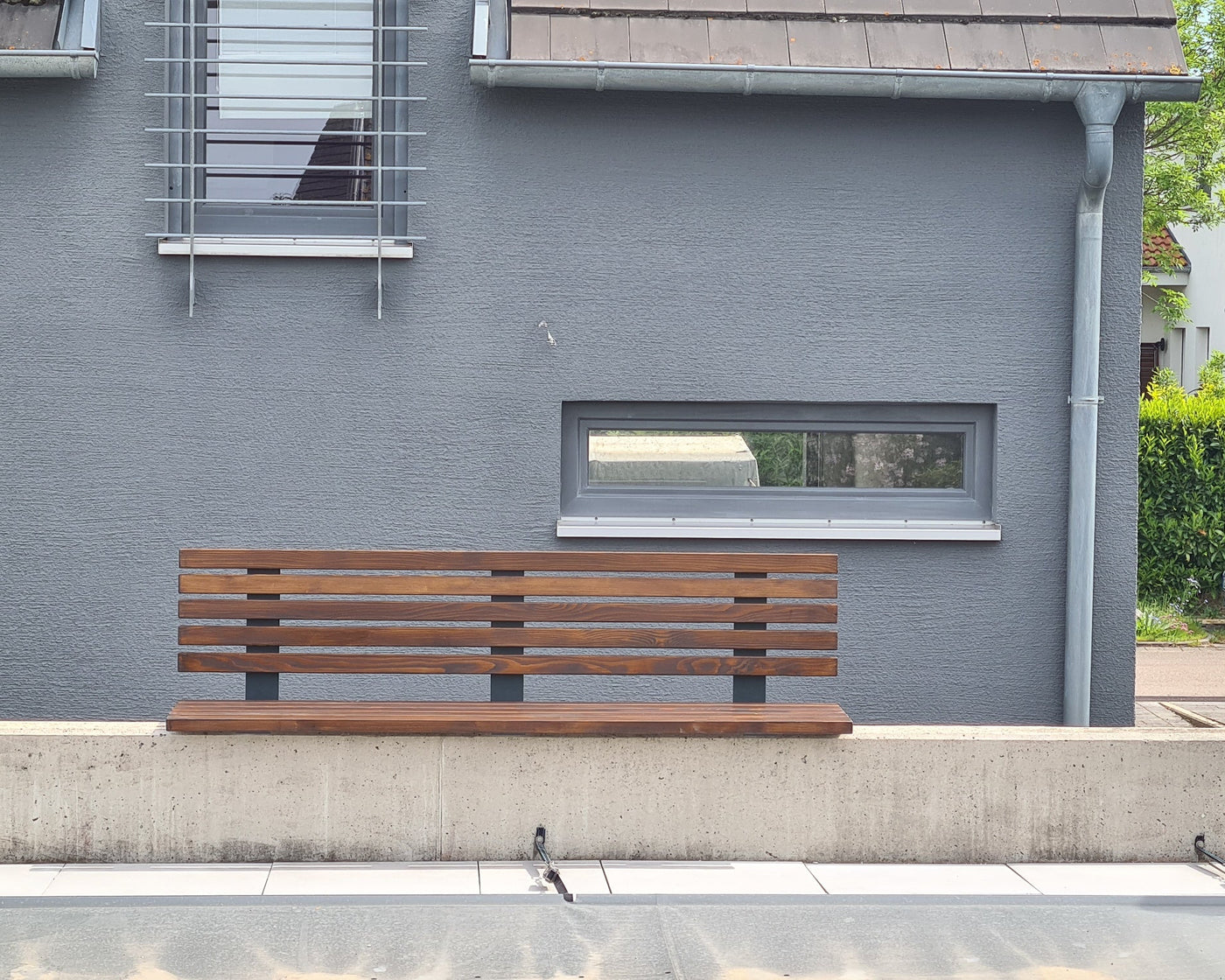 Individuell gefertigte Sitzbank aus Stahl und Holz an einer Hauswand